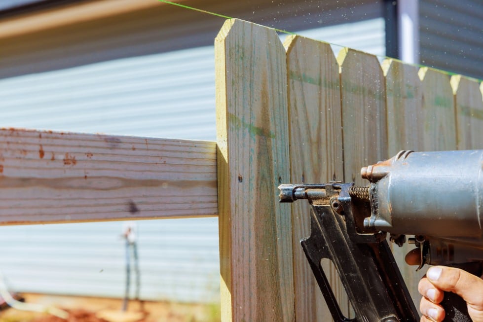 Installation of the wooden fence with a nail gun